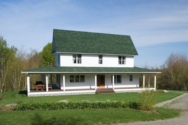 Traditional Farmhouse with gabled roof, full front porch, and classic horizontal siding