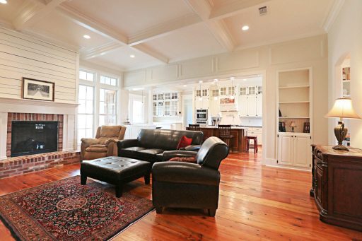 Customized Liberty Plan – Living room with coffered ceiling, nickel gap fireplace, built-ins, and transom windows