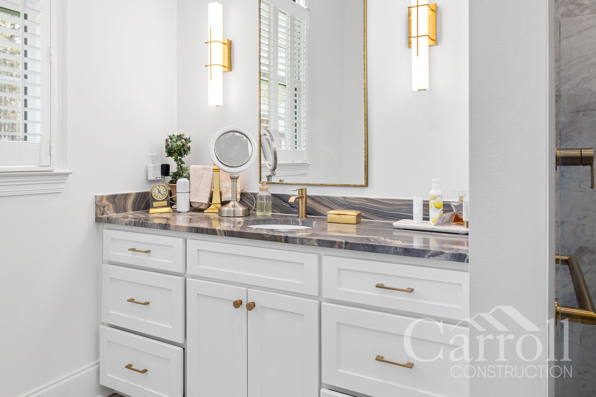Light-Colored Vanity with Brass Finishes – Morrison Mother-in-Law Suite Modern light-colored bathroom vanity with thin-line brass fixtures and subtle toe-kick lighting