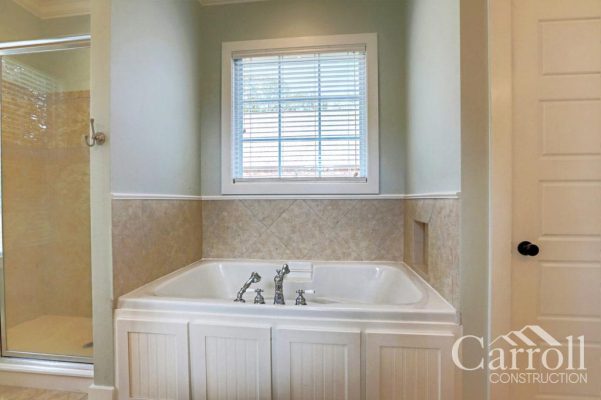 Master bathroom with soaker tub and paneled front surround