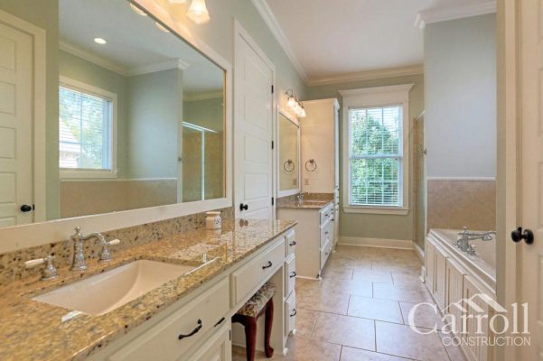 Master bathroom with granite-topped vanities, chrome faucets, undermount sinks, and tile flooring