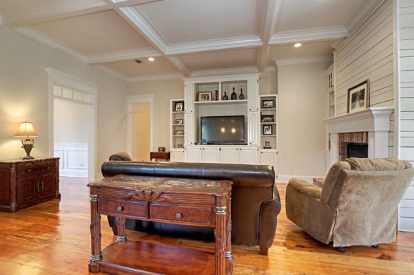 Living room with coffered ceiling and nickel gap paneling around fireplace chase