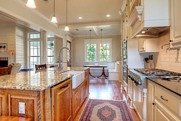 Kitchen view toward breakfast area featuring farmhouse sink and professional gas rangetop