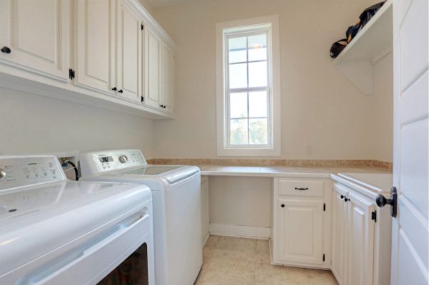 Laundry room with extensive cabinet storage and hanging rod space