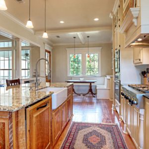Customized Liberty Plan – Kitchen with rangetop, farm sink island, and breakfast nook beyond