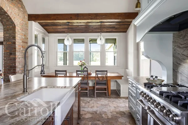 Breakfast nook with pine ceilings, farmhouse sink in foreground, THOR range and granite counters in view