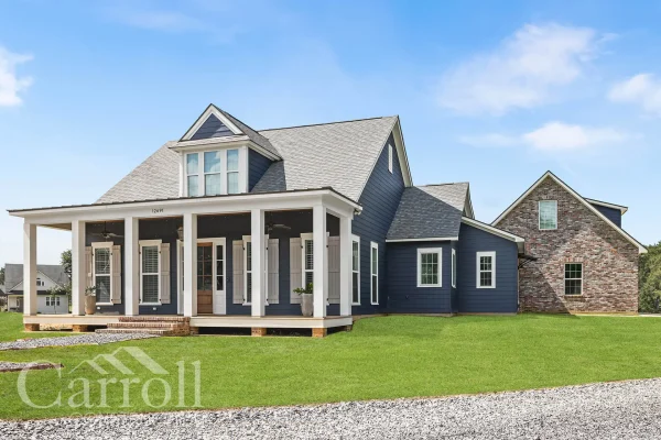 Exterior angle showing garage with brick base, blue siding with white trim, and raised front porch