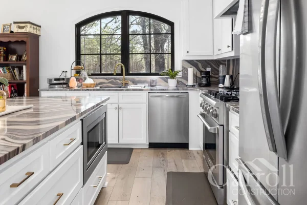 Close-up of kitchen island with built-in microwave, Bosch dishwasher, and granite backsplash